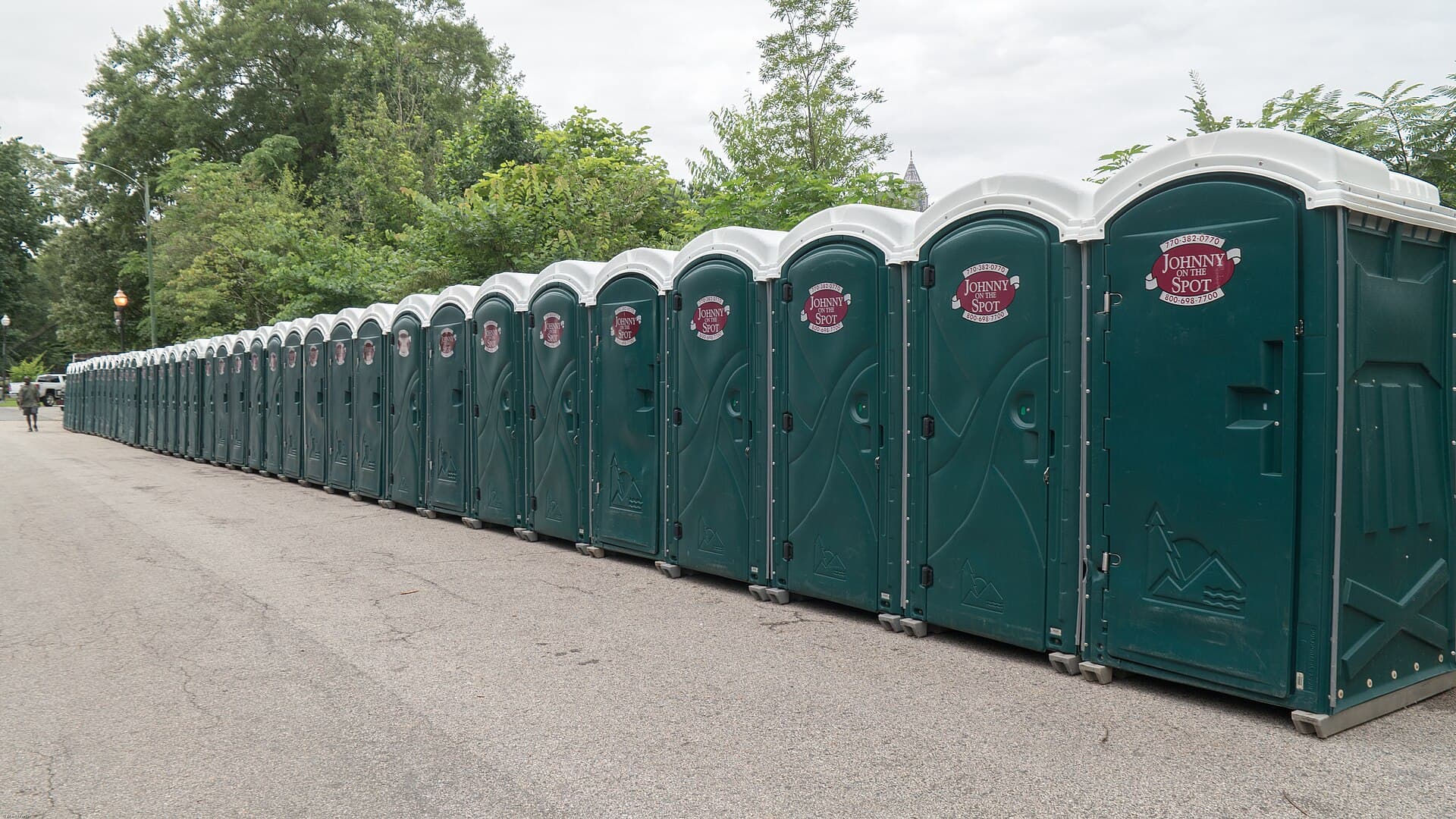 Portable toilets lined up for a large outdoor event